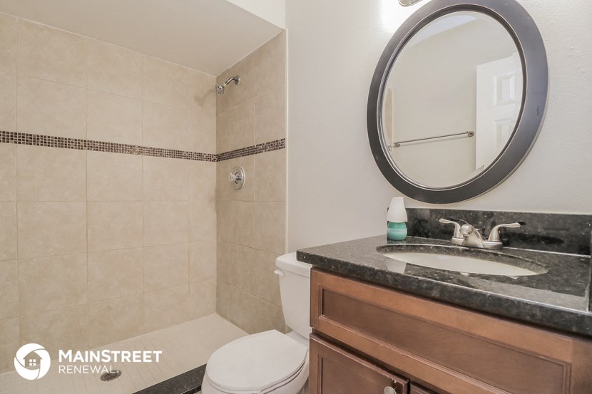 a bathroom with a toilet and a sink and a mirror