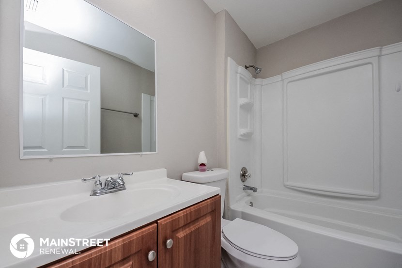 a bathroom with a sink toilet and a mirror