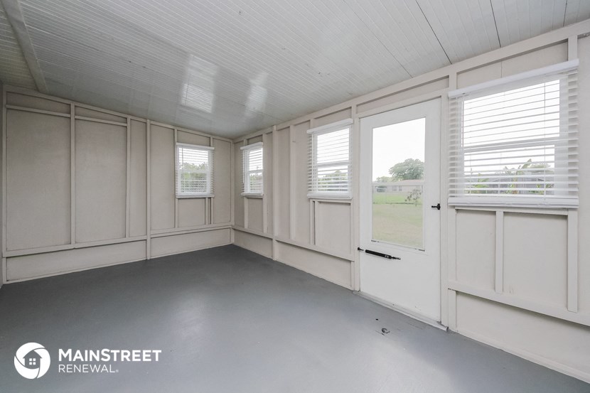 the interior of a screened in porch with windows and a door