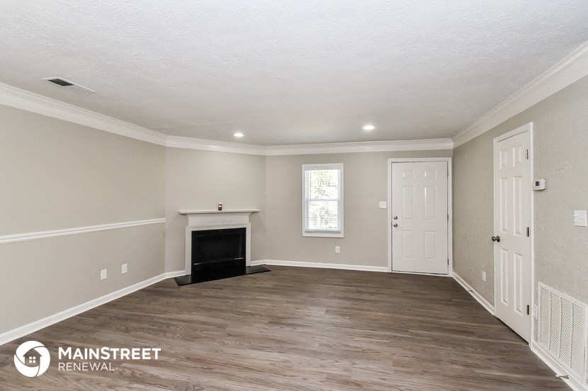 the living room of this home has a fireplace and hardwood floors