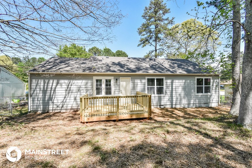 a small white house with a deck in front of it