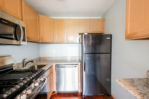 a kitchen with stainless steel appliances and wooden cabinets