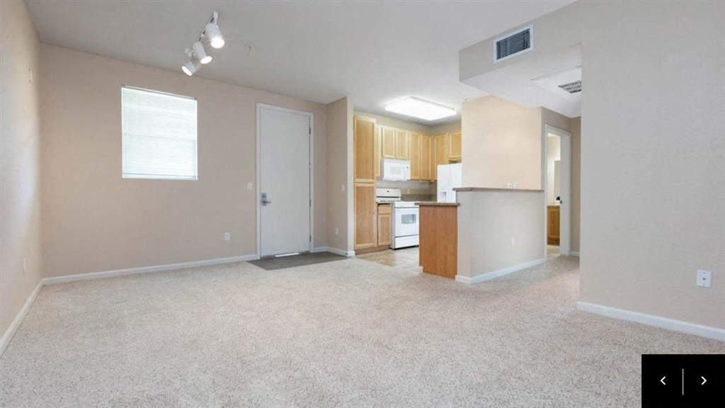 an empty living room and kitchen with a white floor