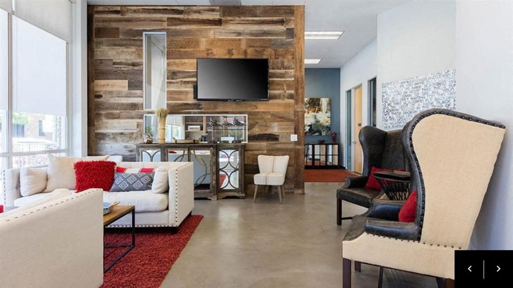 a living room with a couch and chairs and a television