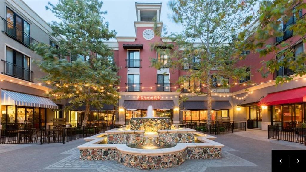 a courtyard with a fountain and a clock tower