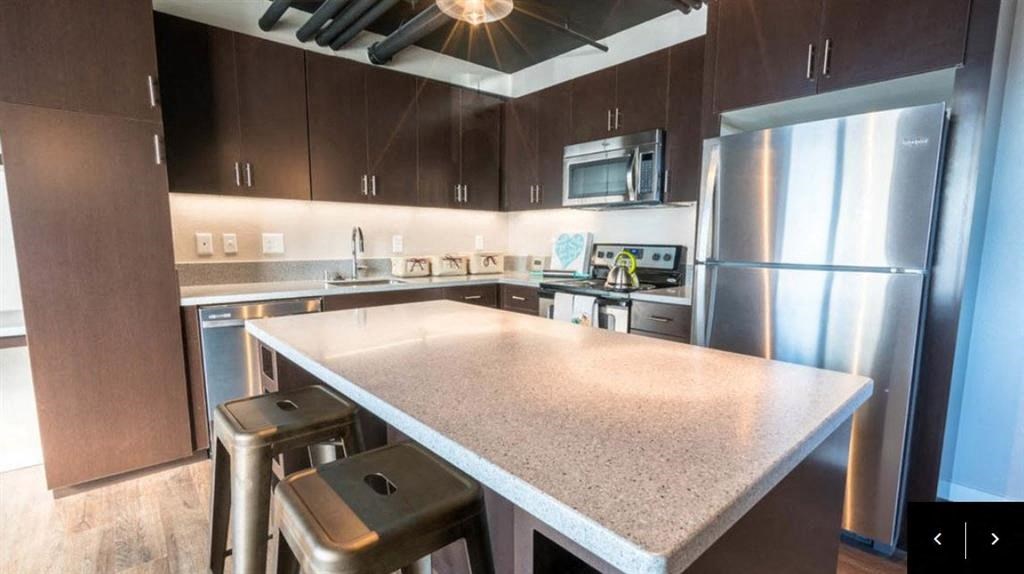 a kitchen with a counter top and a stainless steel refrigerator