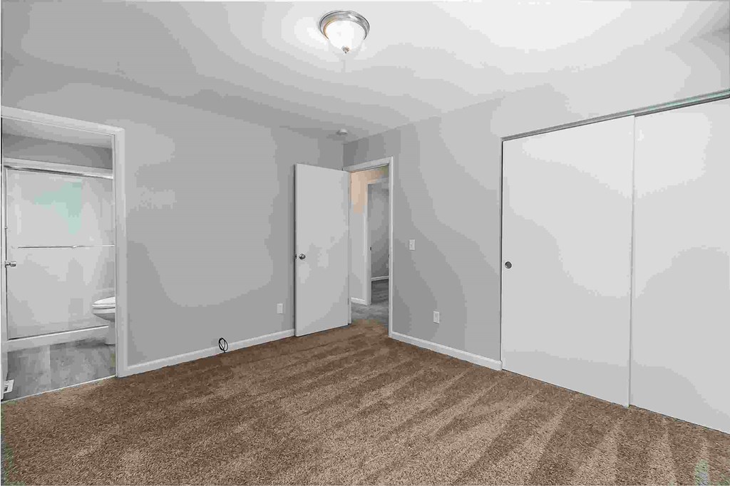 A room with a carpeted floor and a ceiling light.
