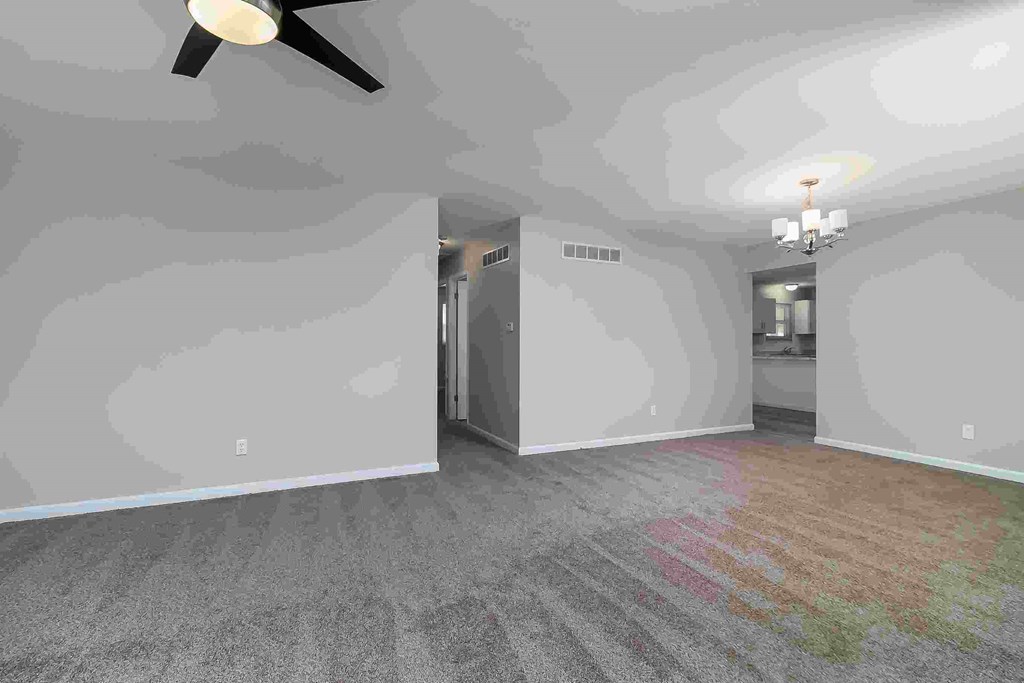 A room with a ceiling fan and a light fixture.