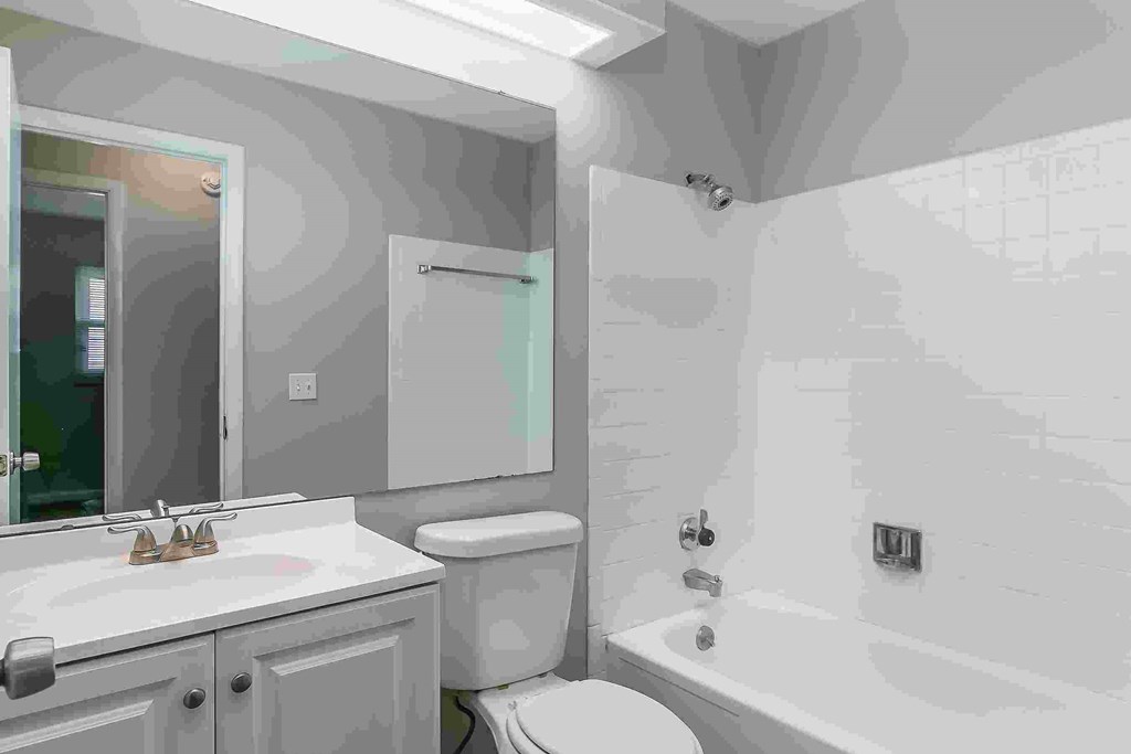 A bathroom with a toilet, sink, and bathtub.