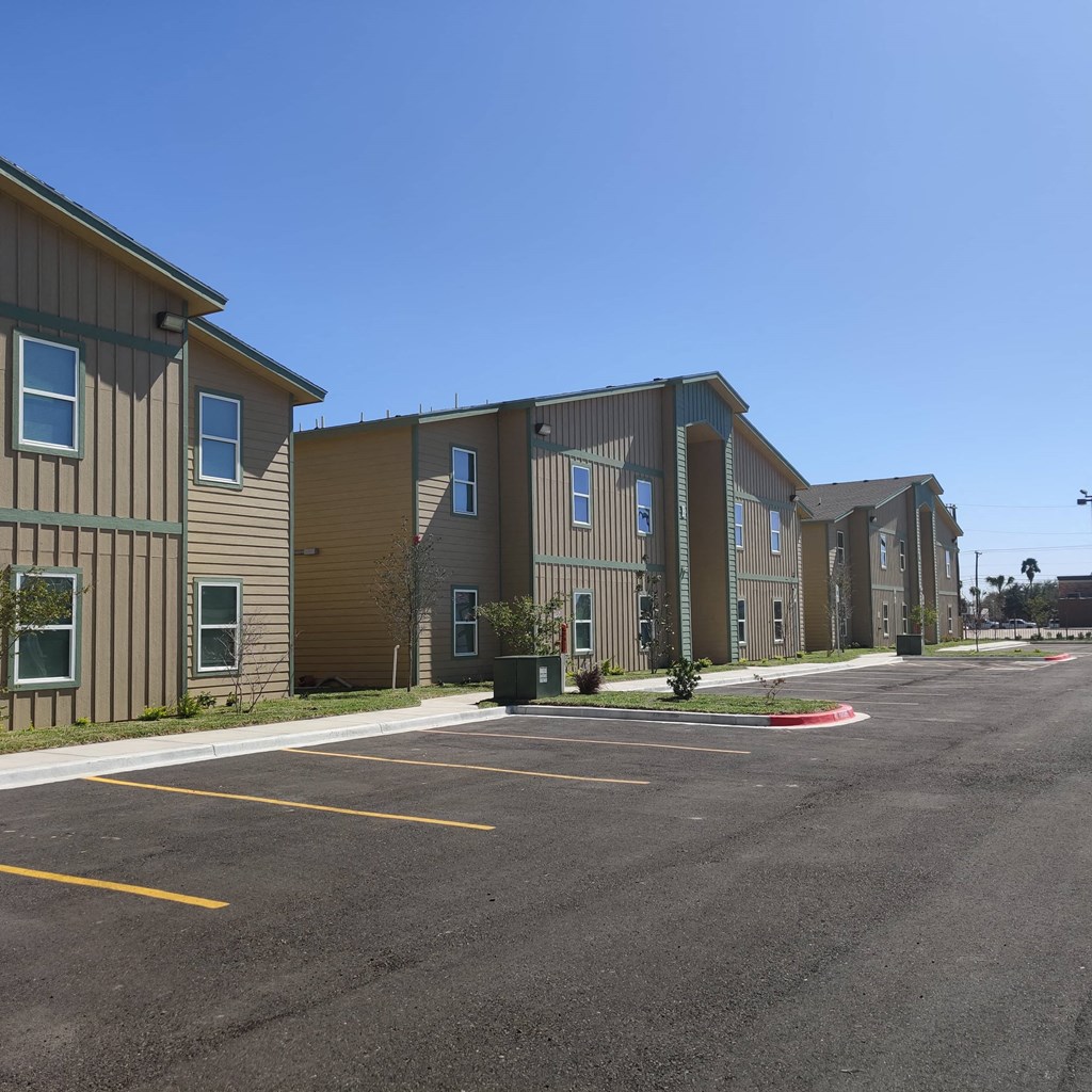an empty parking lot in front of an apartment building