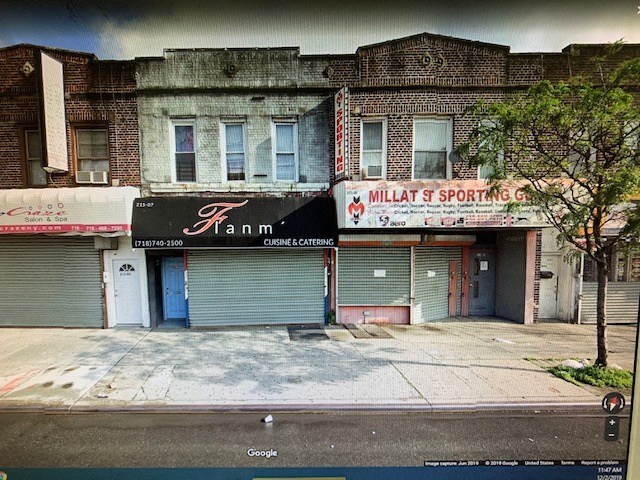 A street view of a building with a closed blue door and a sign that says "Fann".