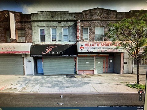 A street view of a building with a closed blue door and a sign that says "Fann".
