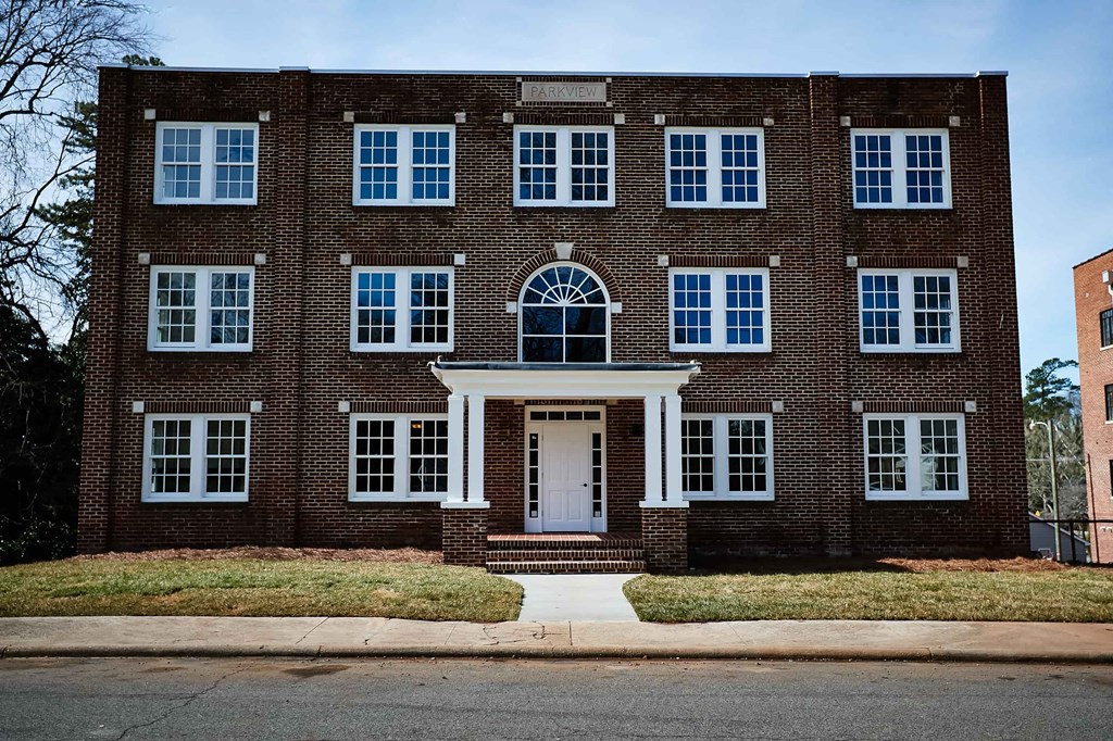 the front of a brick building with a white front door