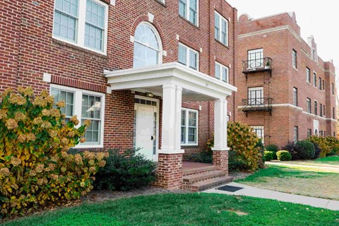 A red brick building with a white door and windows.