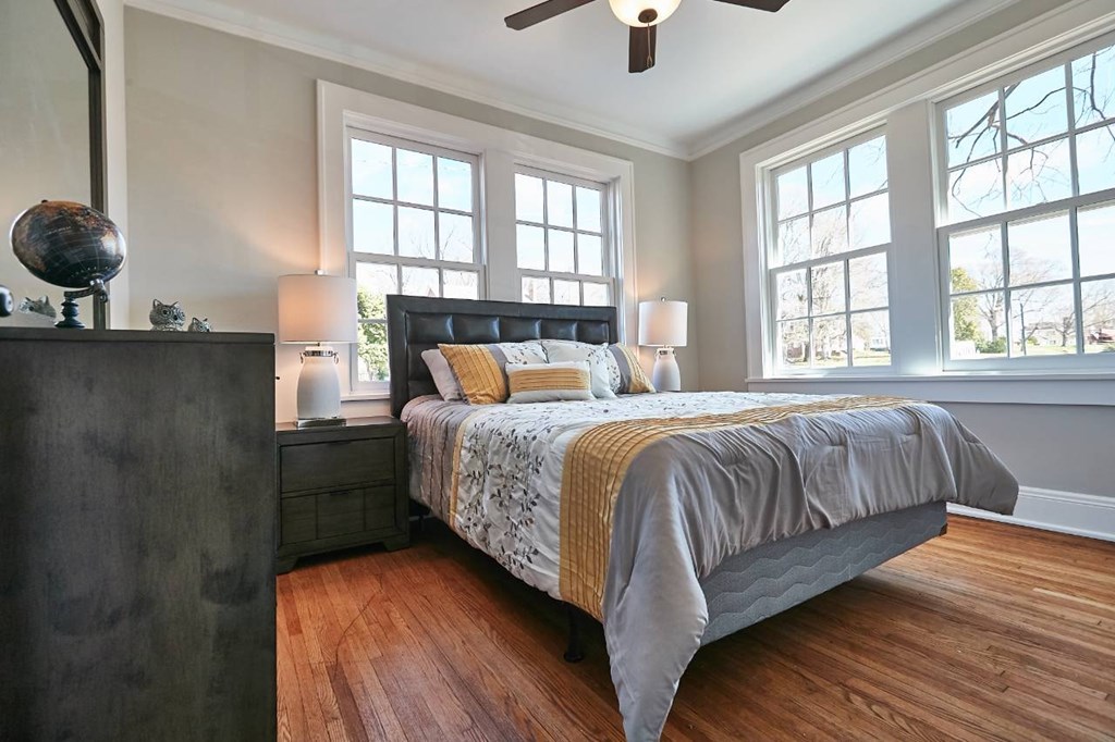 A bedroom with a bed, nightstand, and a ceiling fan.