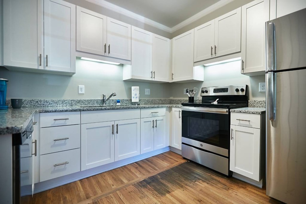 A kitchen with white cabinets and a granite countertop.