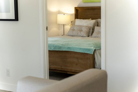 a bedroom with a bed and a chair and a lamp