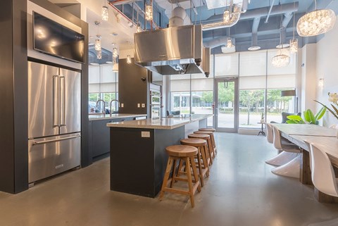 a kitchen with stainless steel appliances and a long island with bar stools