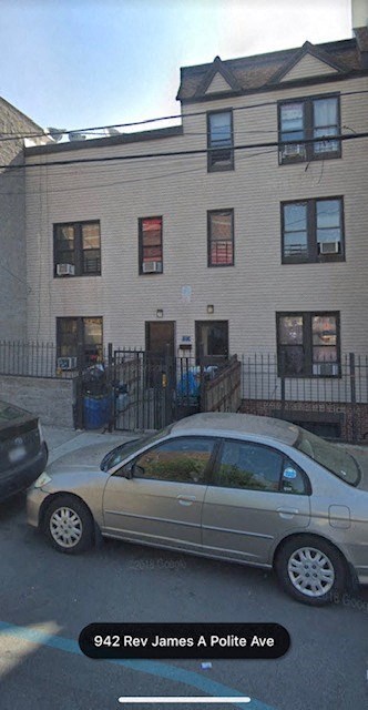 A car is parked in front of a building with the address 942 Rev James A Polite Ave.