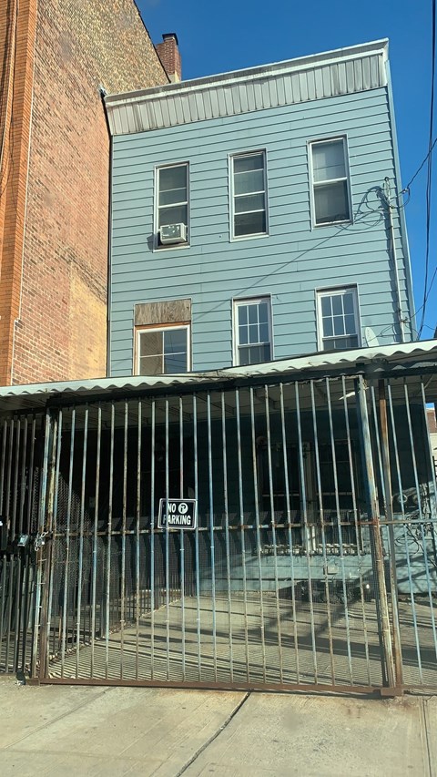 a blue building with a fence in front of it