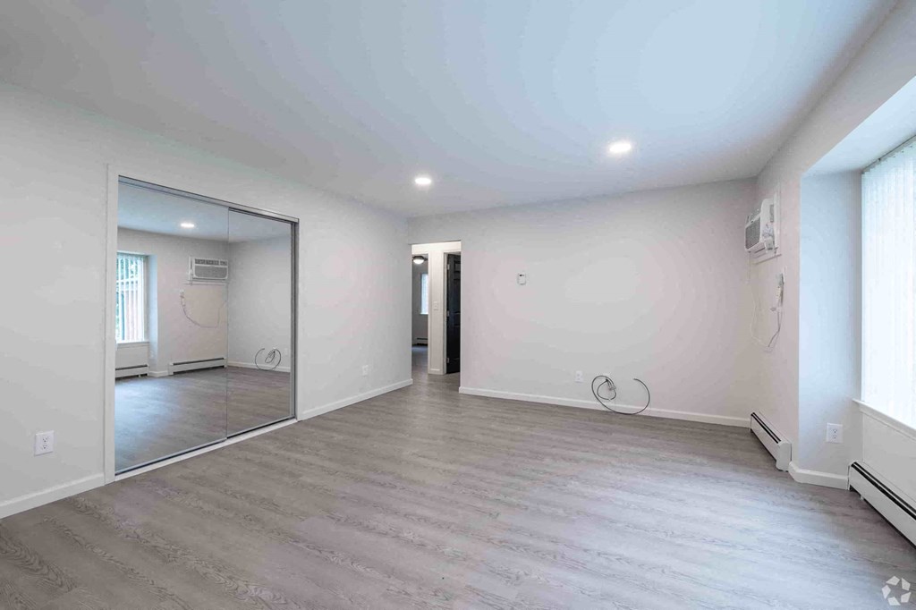 a living room with a mirror and a white wall