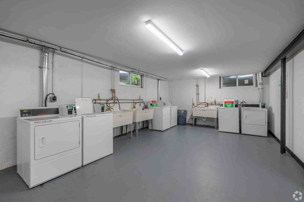 a laundry room with washing machines and sinks and a washer and dryer