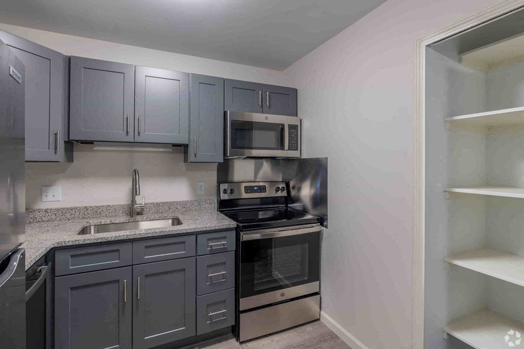 a kitchen with black appliances and gray cabinets