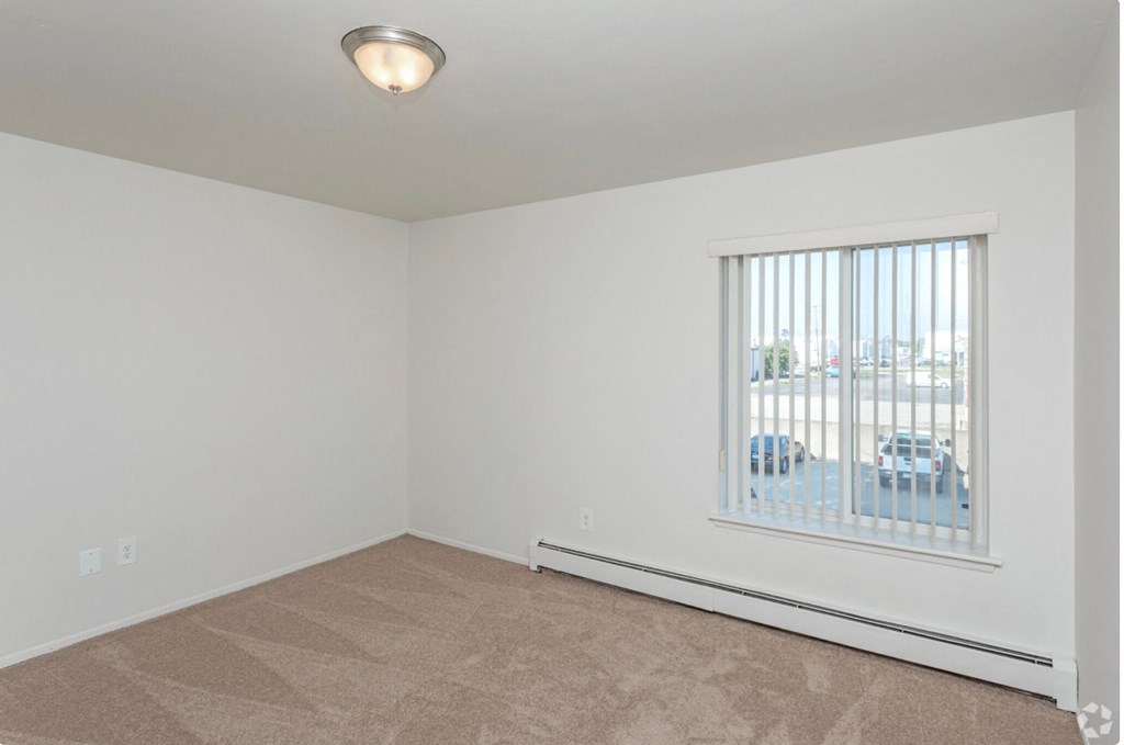 the living room of an empty home with a large window