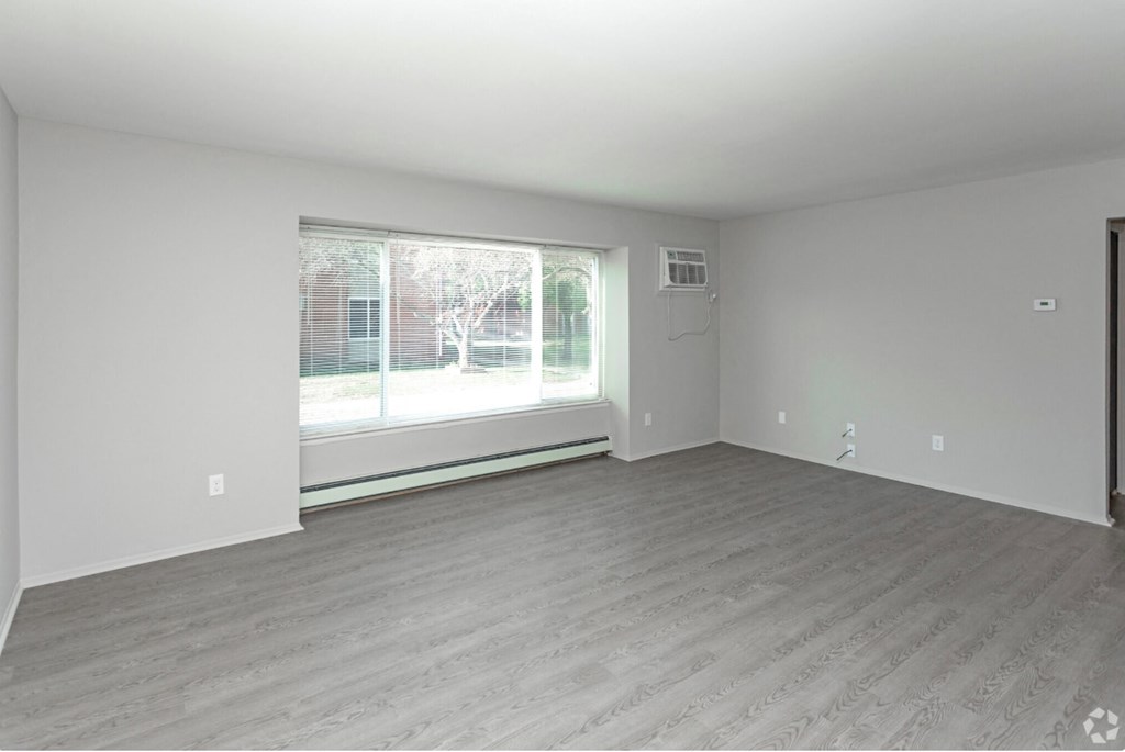 the living room of an empty house with a large window