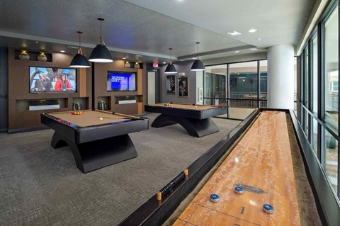 A room with a pool table and a TV screen.