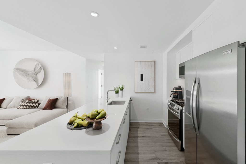 a kitchen with stainless steel appliances and a counter with a bowl of fruit