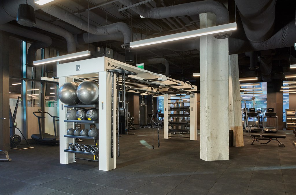 a workout room with weights and other equipment in a building with pipes