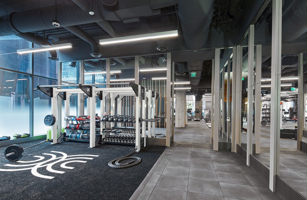 a view of the fitness center with weights machines and glass walls