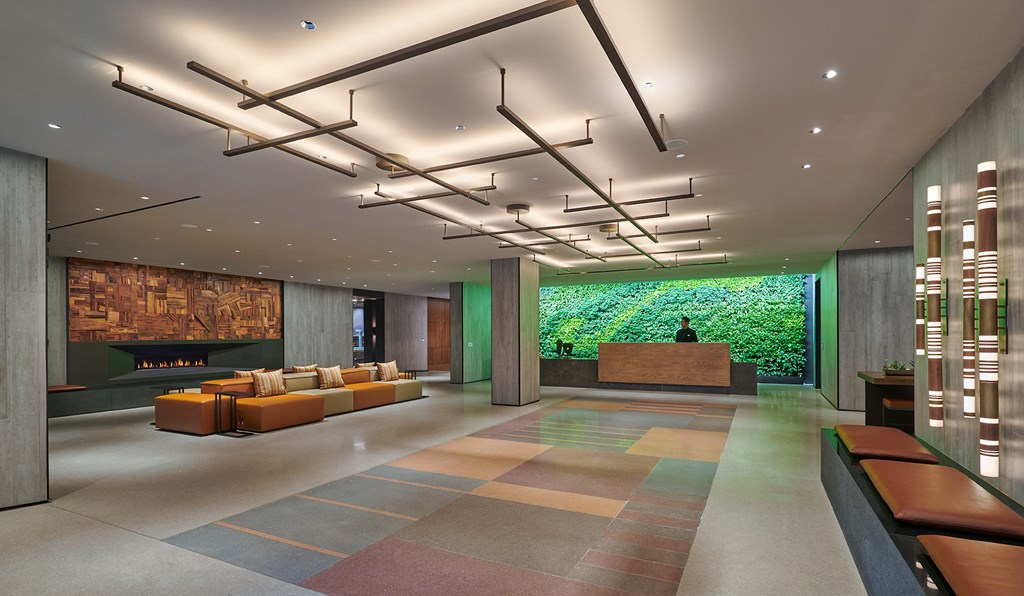 a lobby with couches and a fireplace and a wall ofenery