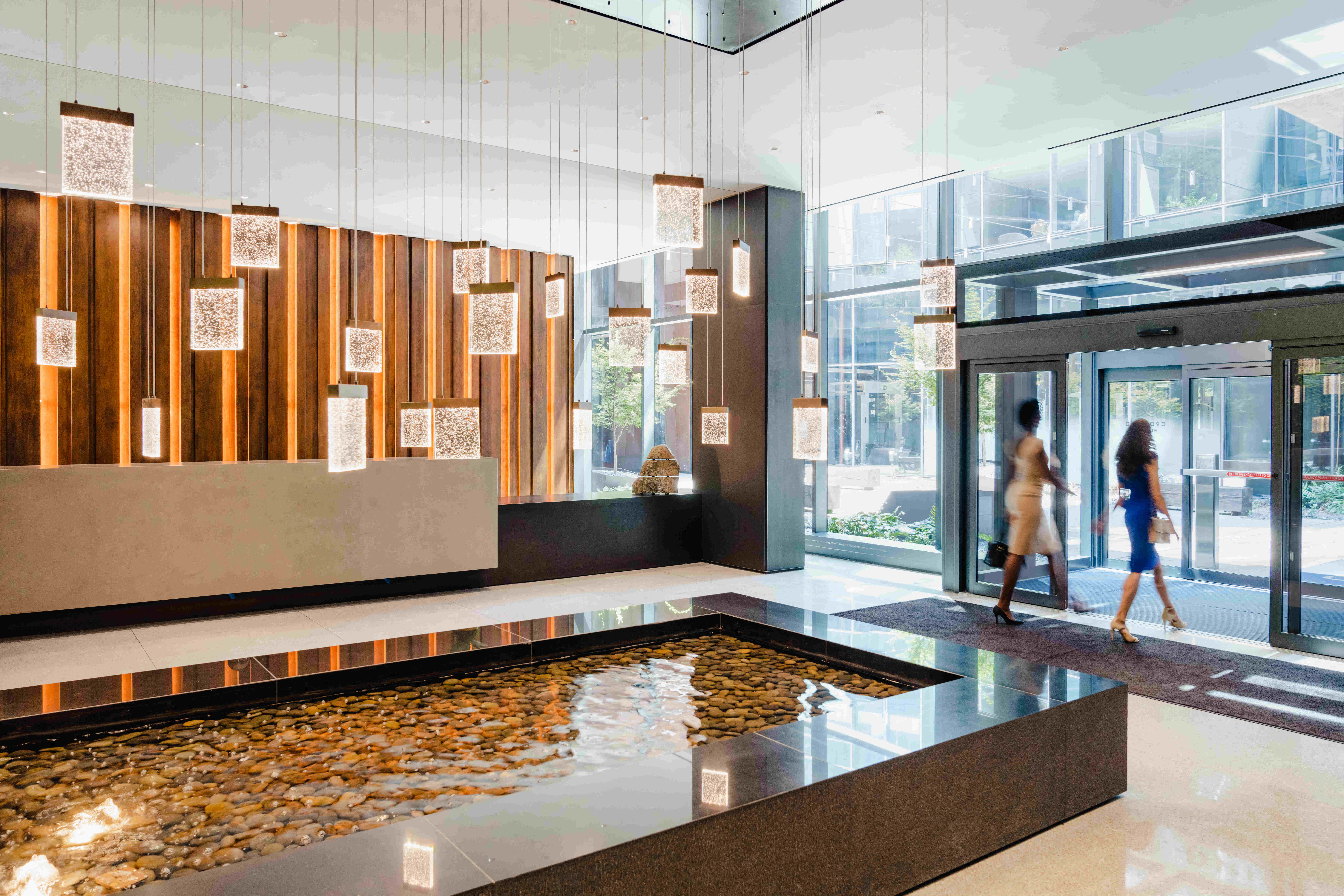 Well lit lobby with water feature and lighting fixtures