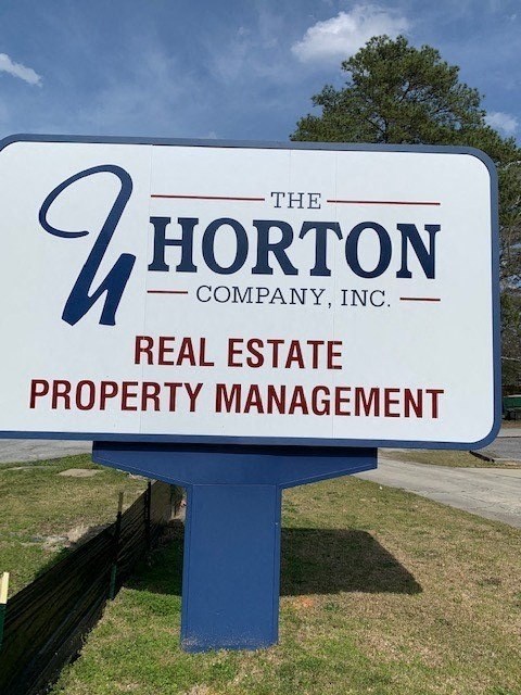 a sign for the horton company on the side of a road
