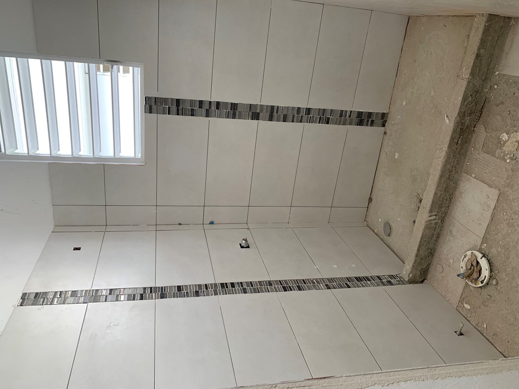 a tiled shower in a bathroom with a window