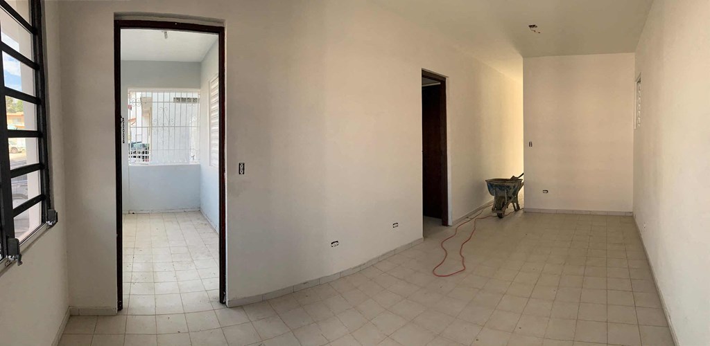 an empty living room with white walls and a tile floor