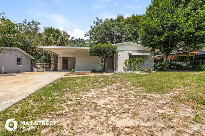 a house with a yard and a driveway and trees