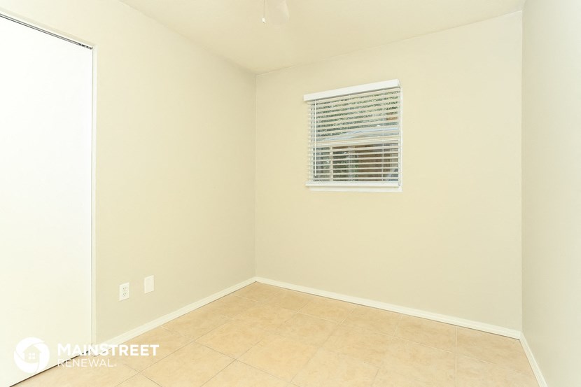 an empty room with a window and a tiled floor