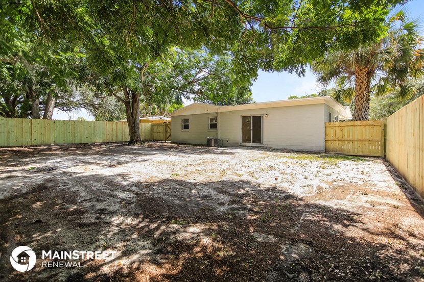 a house with a yard and a fence and trees