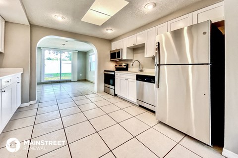 the kitchen is clean and ready to use with white cabinets and stainless steel appliances