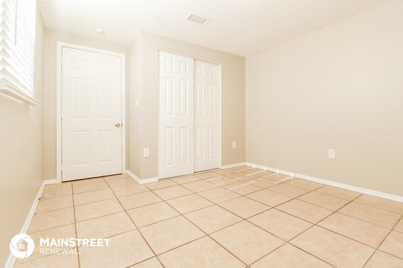 an empty room with two doors and a tiled floor