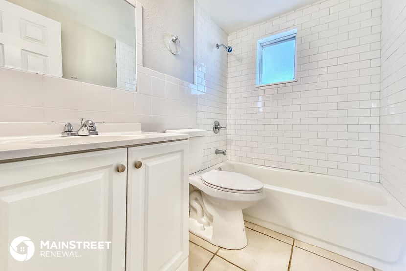a white bathroom with a toilet and a sink and a bath tub
