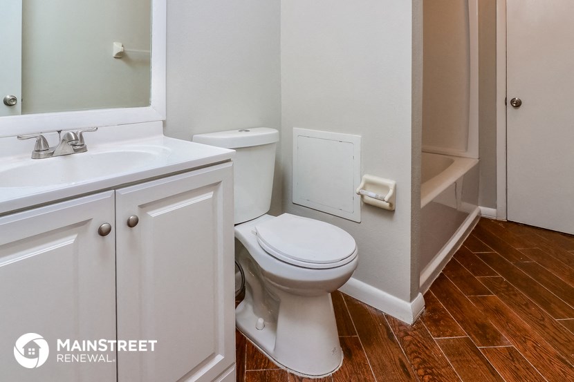 a bathroom with a toilet and a sink and a mirror