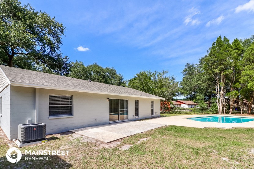 a backyard with a pool and a white house