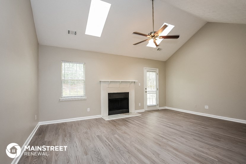 the living room with fireplace and ceiling fan