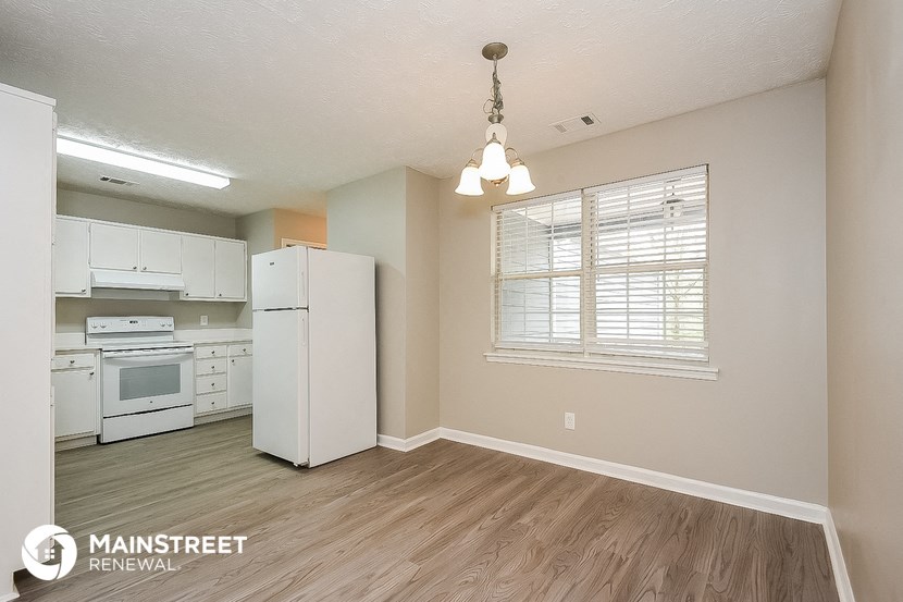 the kitchen of an apartment with white appliances and a window