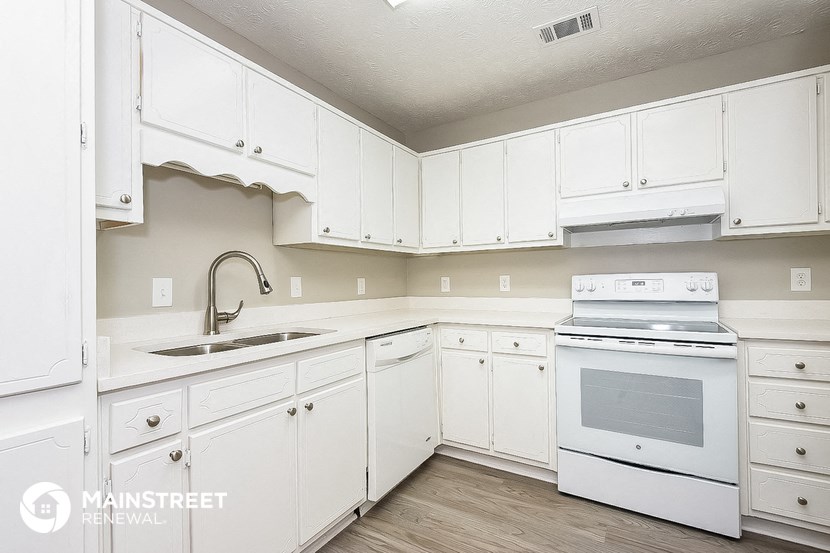 a kitchen with white cabinets and a sink and a stove