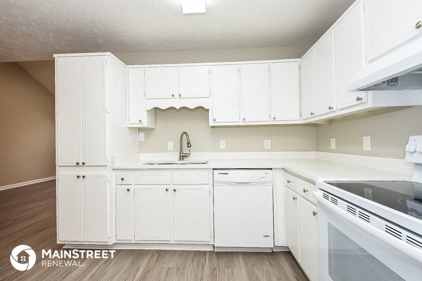 a white kitchen with white cabinets and white appliances